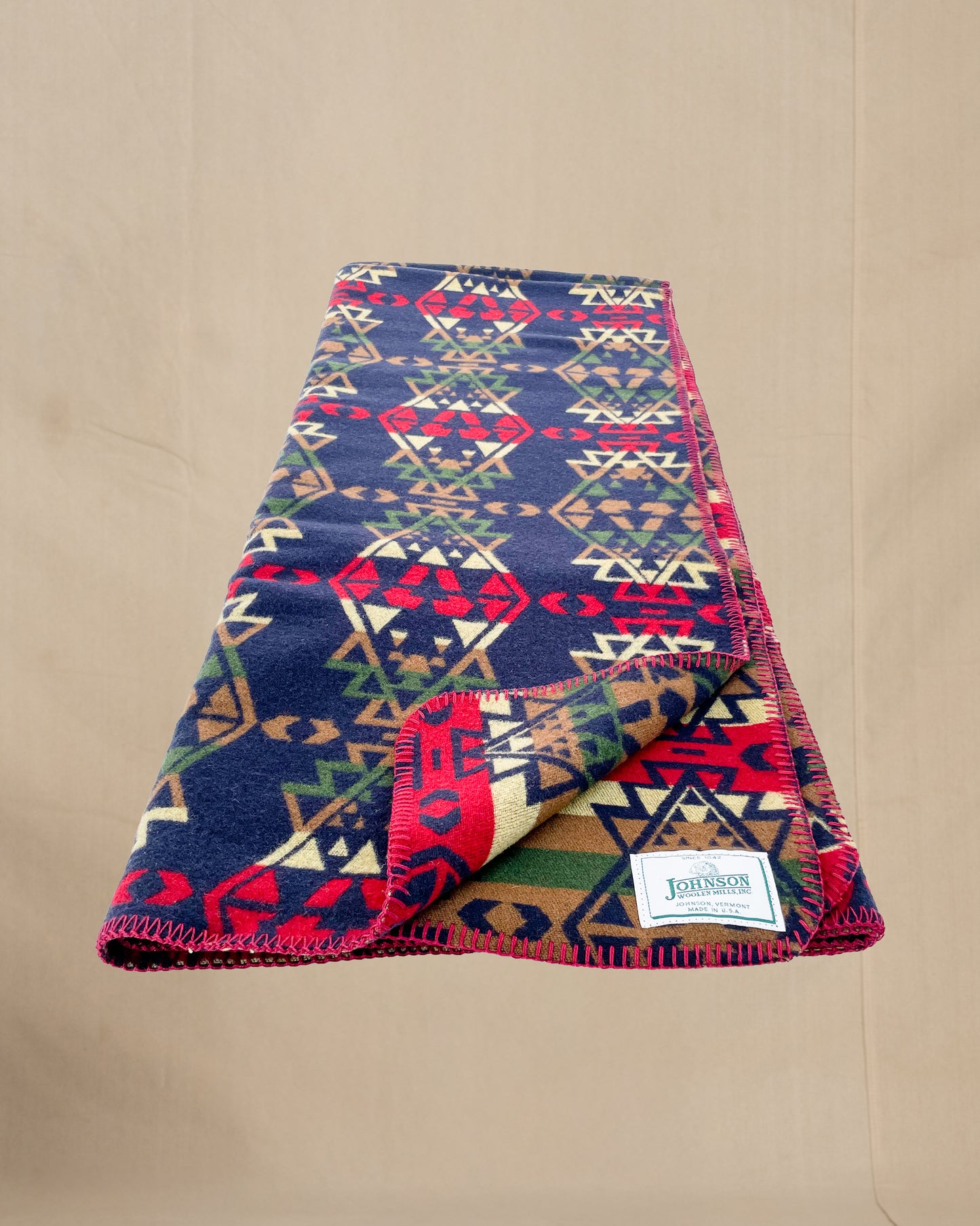 Johnson Woolen Mills throw - Blue, red, yellow native American print laying