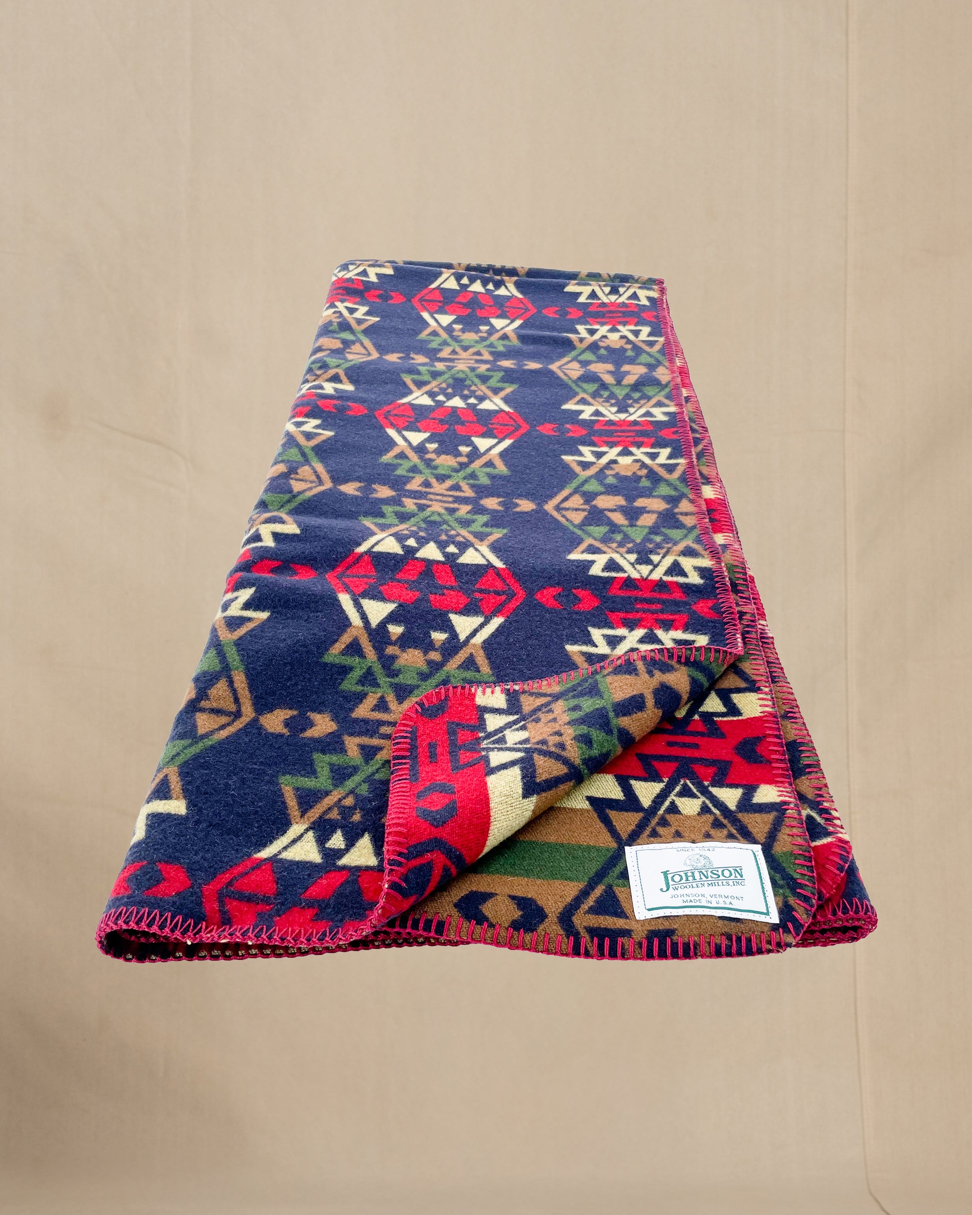 Johnson Woolen Mills throw - Blue, red, yellow native American print laying
