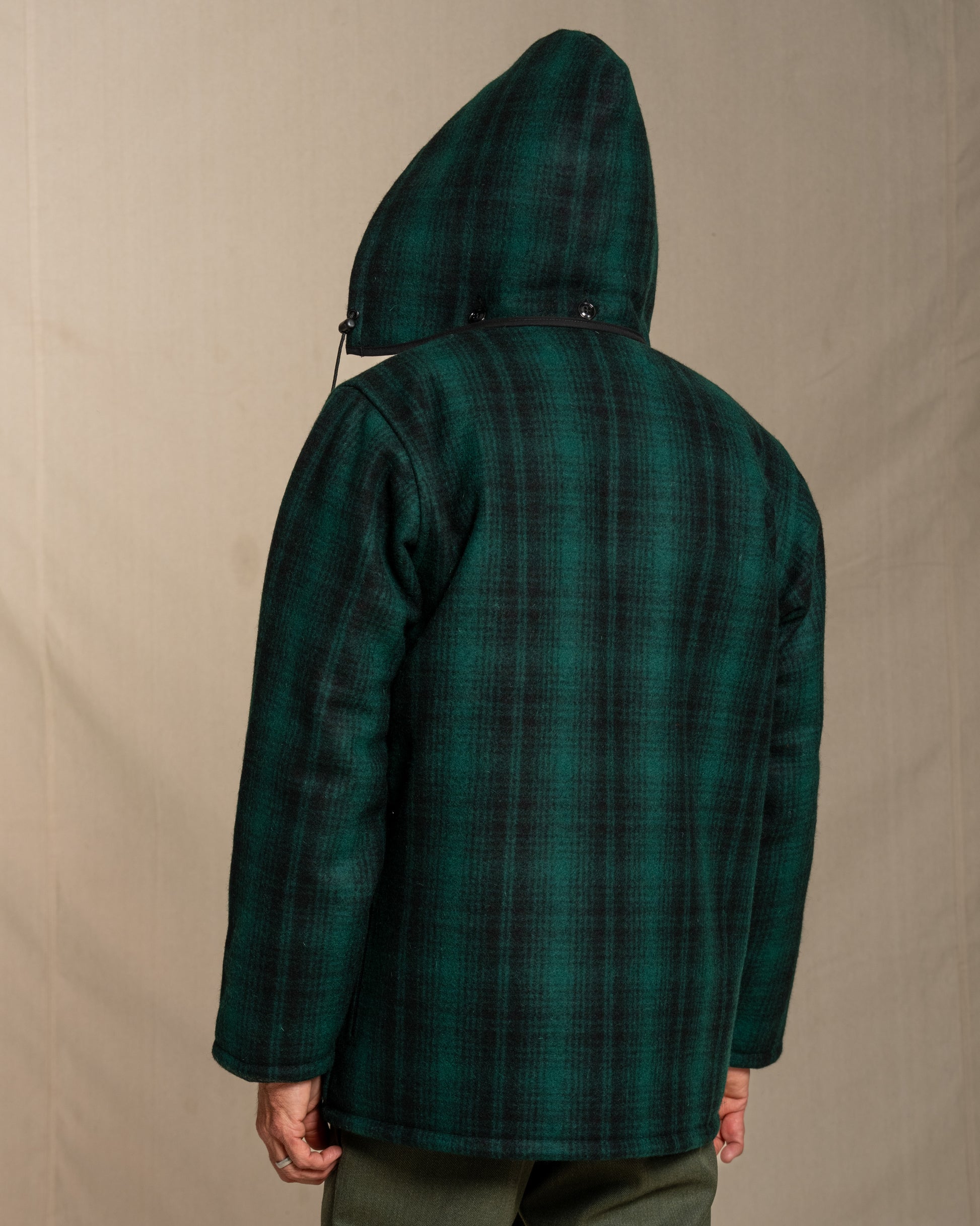 Green plaid coat with hood on a beige background