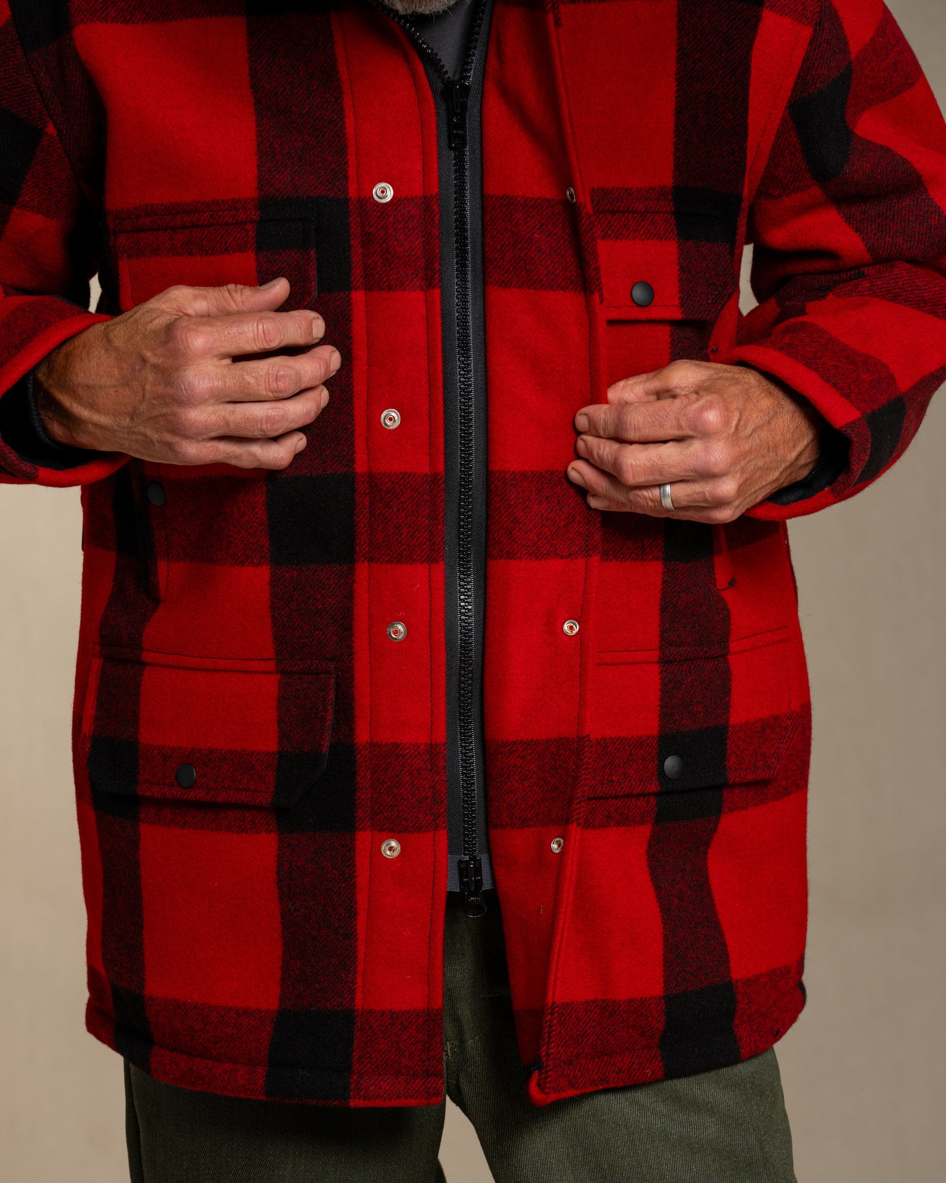 Red and black plaid jacket worn by a person on a beige background