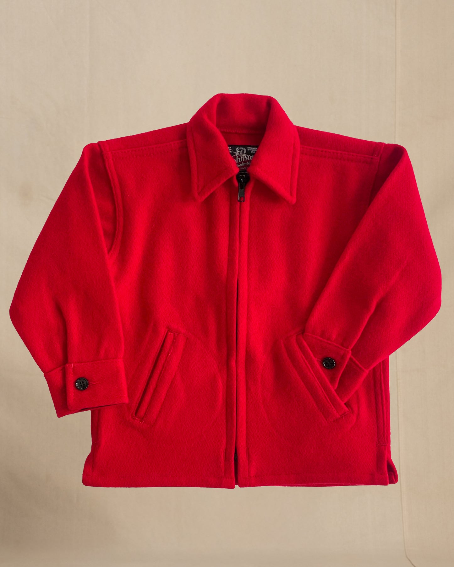 Children's Red coat with black buttons on a beige background