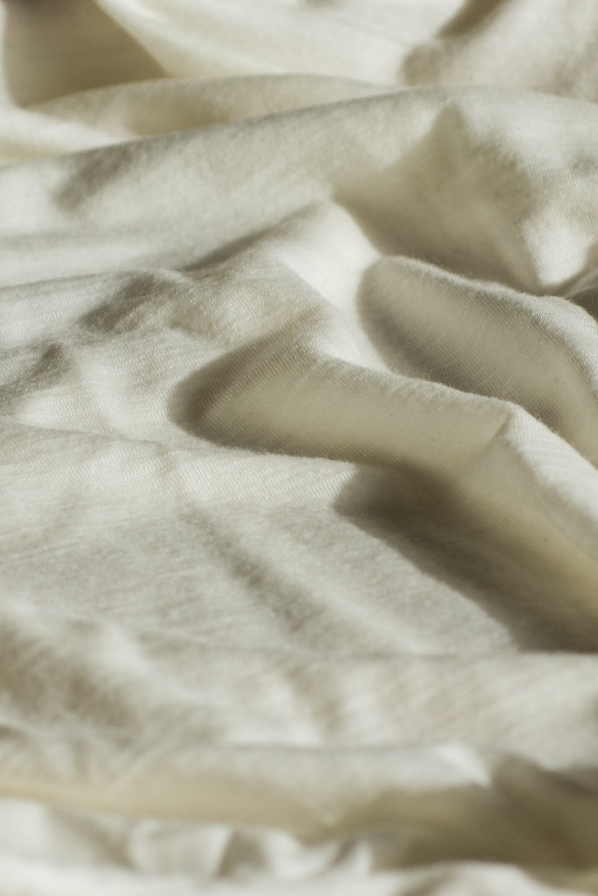 A close-up of cream-colored merino wool fabric