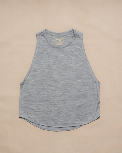A gray sleeveless merino wool tank top laid flat on a light beige background.