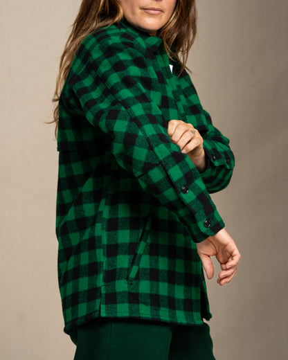 Woman wearing a green and black checkered wool jac shirt against a beige background