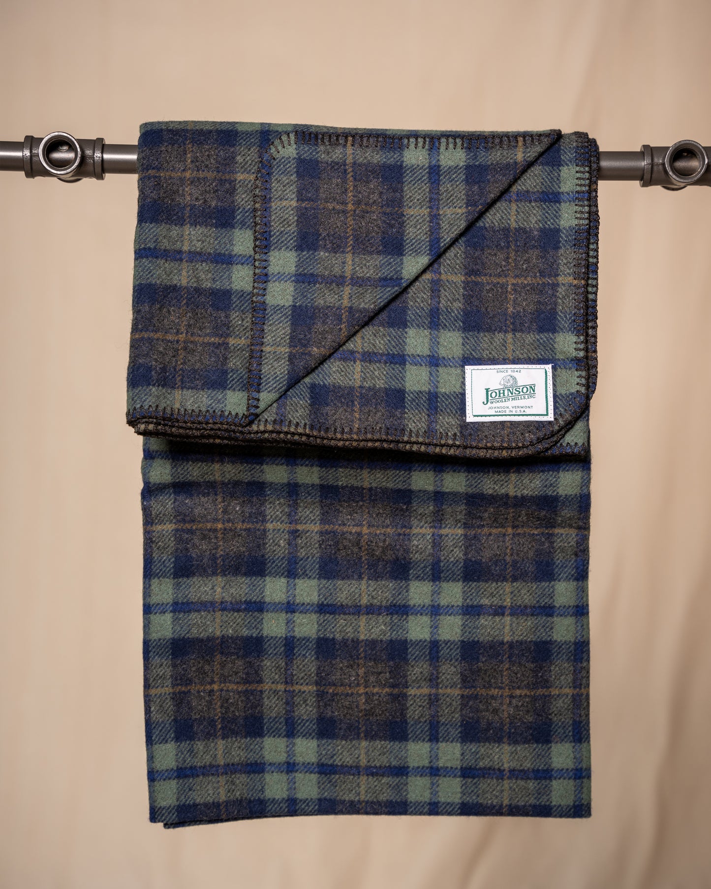 Plaid fabric with a visible brand label on a beige background