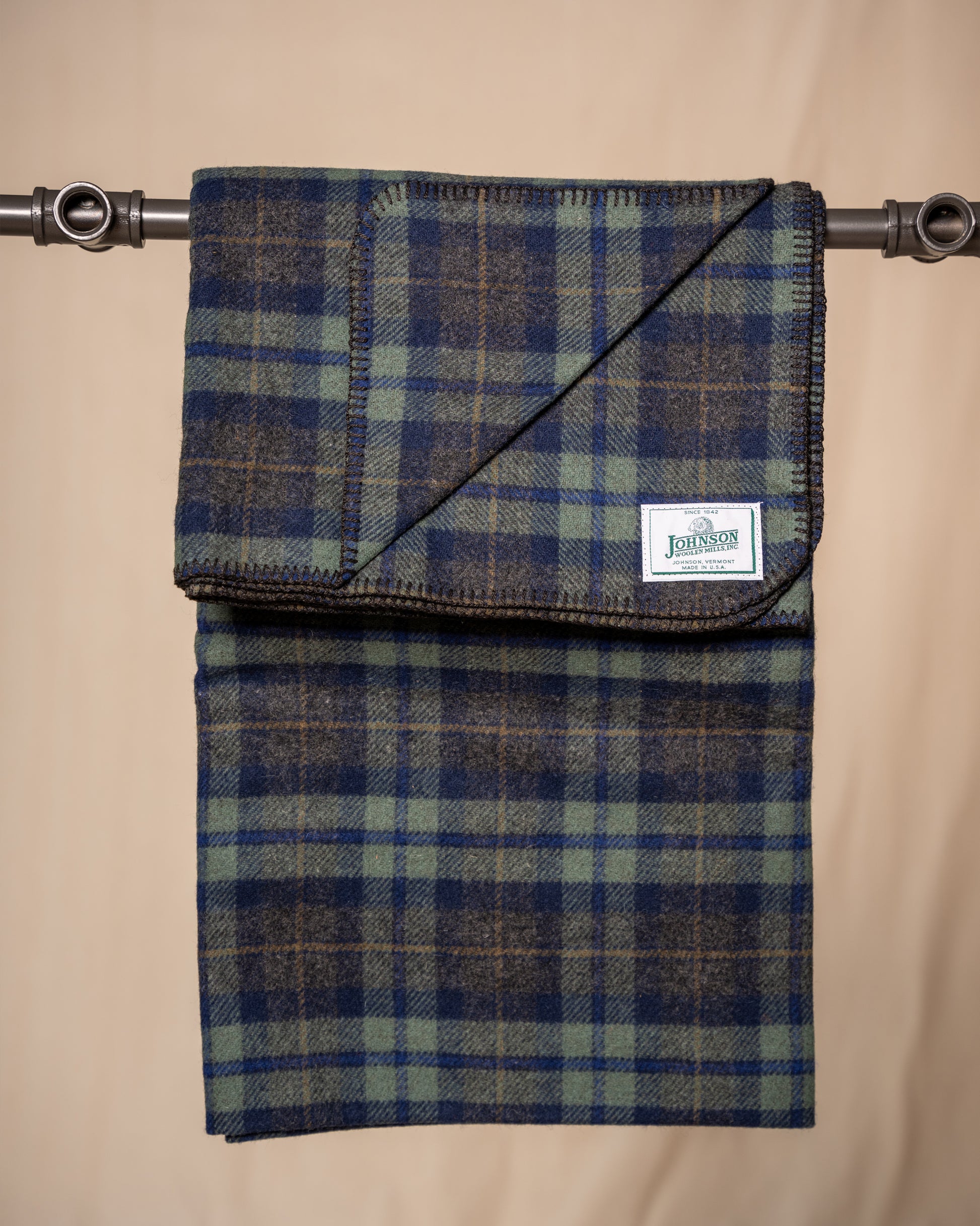 Plaid fabric with a visible brand label on a beige background