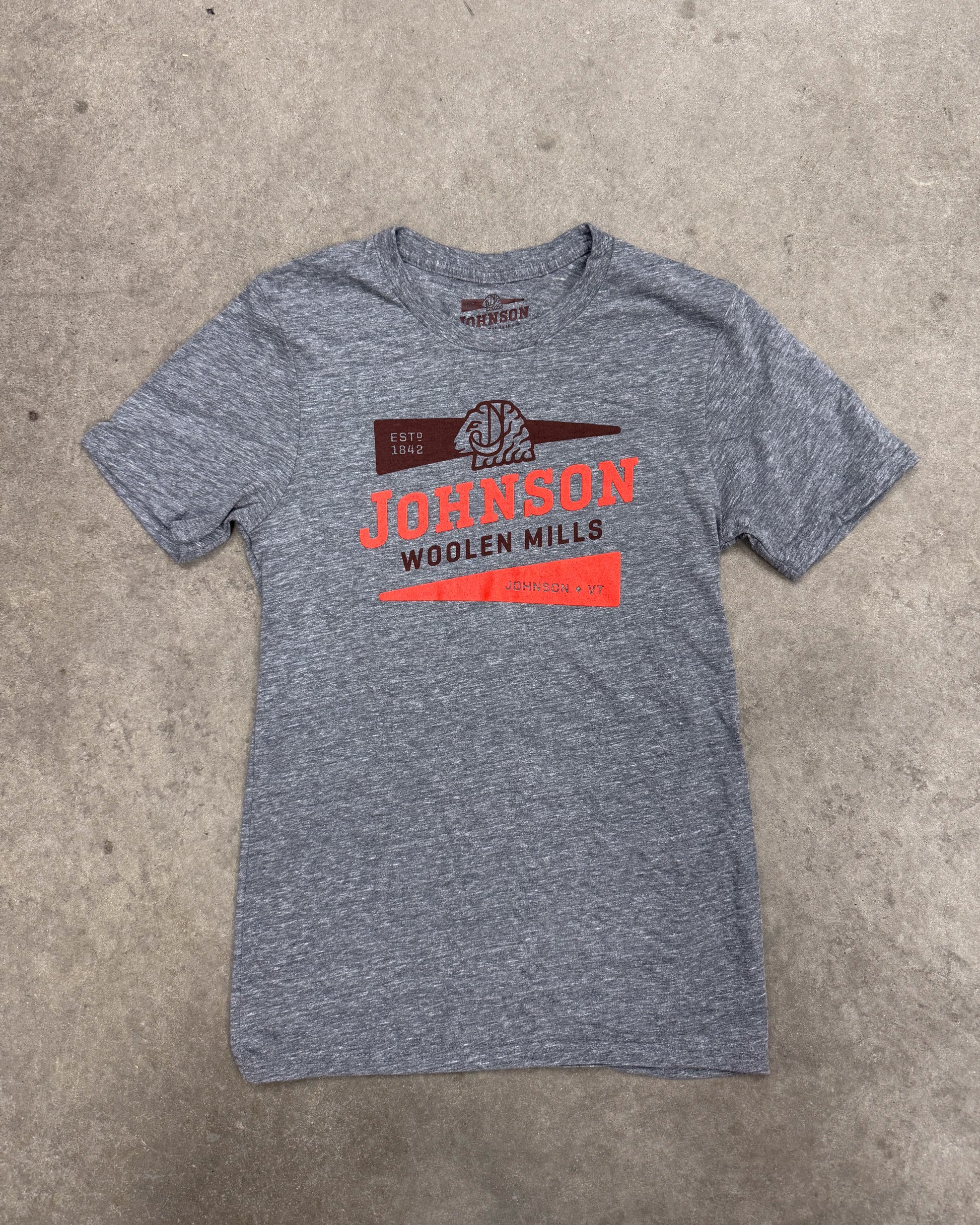 Gray t-shirt with red and white text and logo on a concrete surface