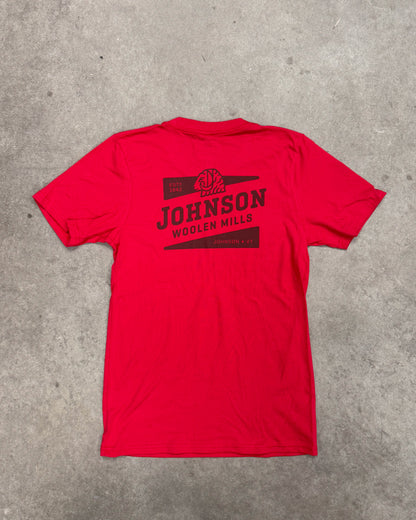 Red t-shirt with black graphic and text on a gray concrete surface