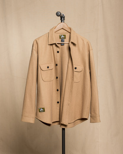 tan wool button down shirt hanging from black steel pipe