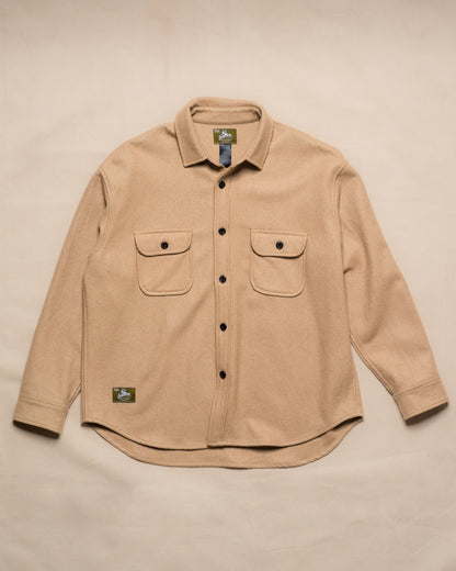 A beige long-sleeve button-up shirt with two chest pockets, laid flat on a light beige background.