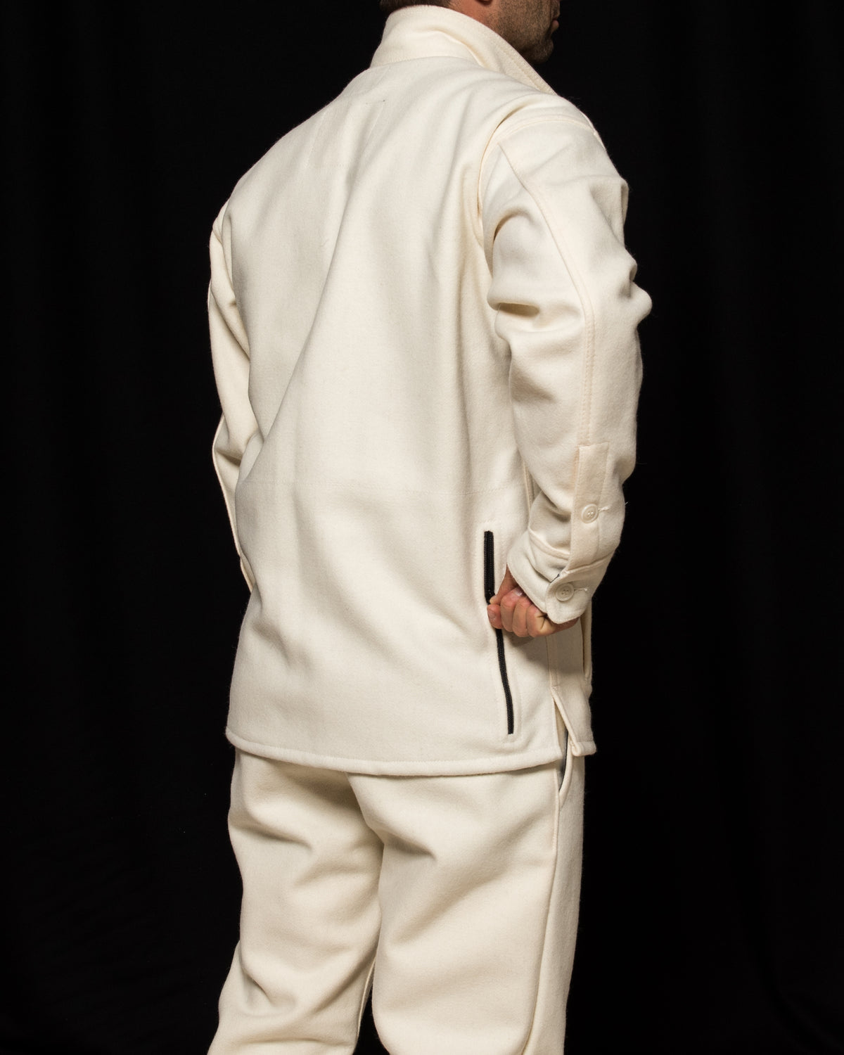 White-out Tracker jacket made from 100% white wool model unzipping game pouch in back