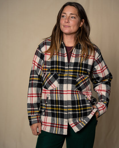 Woman wearing a plaid shirt against a beige background