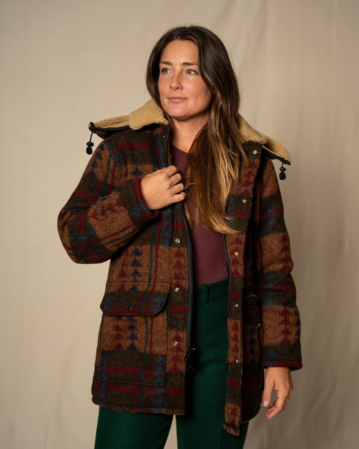 Woman wearing a plaid coat with a neutral background