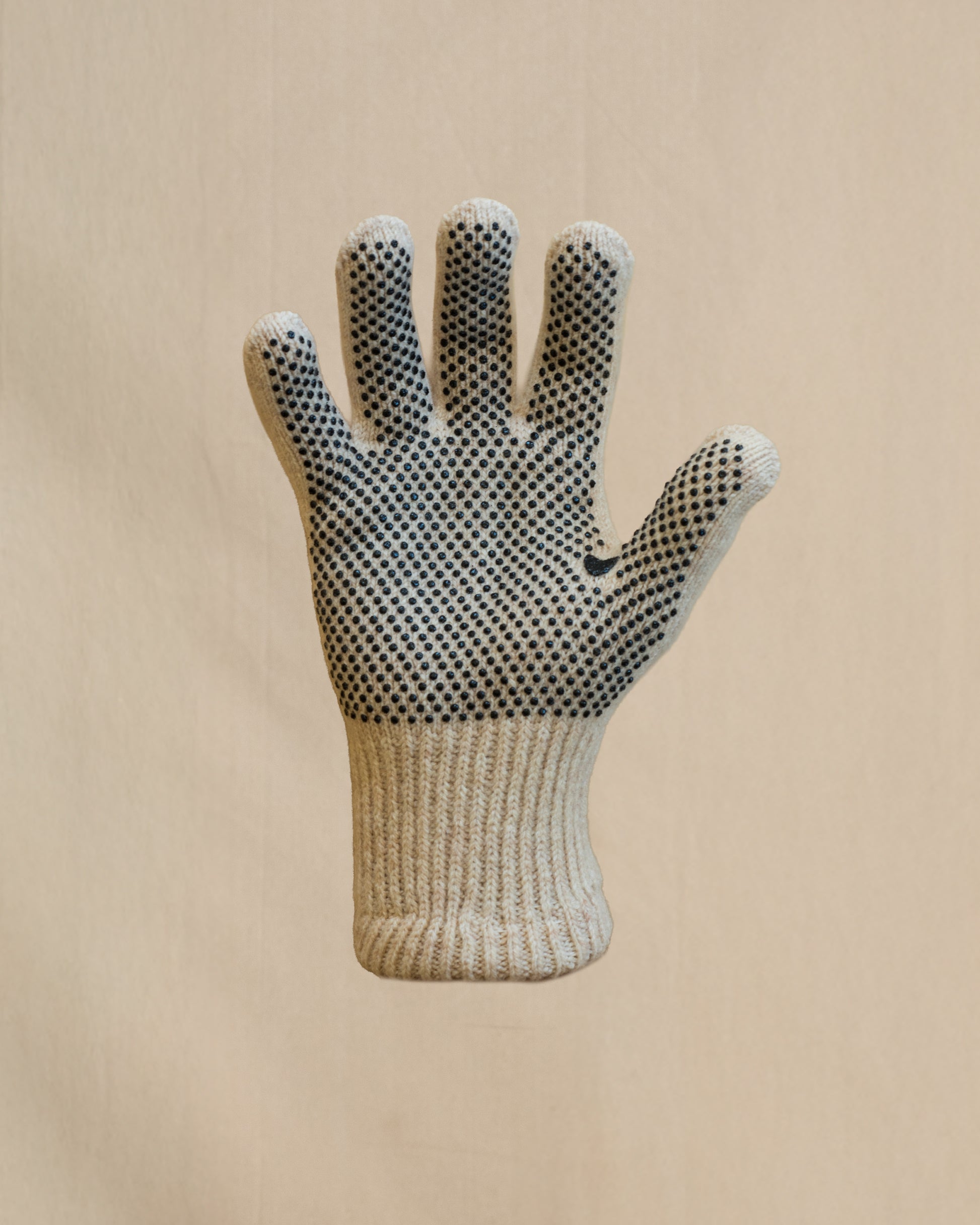 A single knit merino wool  glove with black grip dots