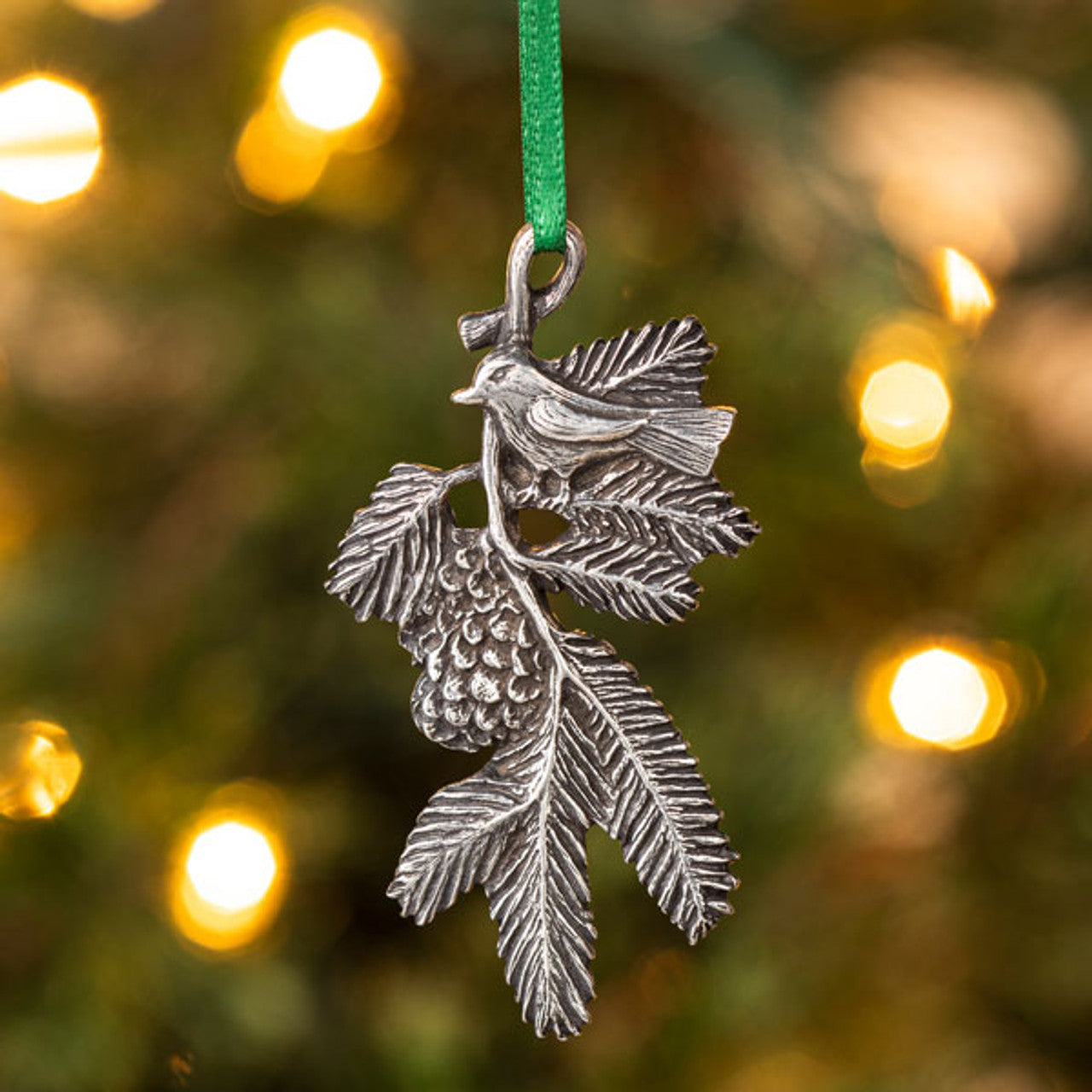 Danforth Pewter Bird on a Bough Carded Ornament. Bird on a branch with leaves and pinecone. Hanging from christmas tree.