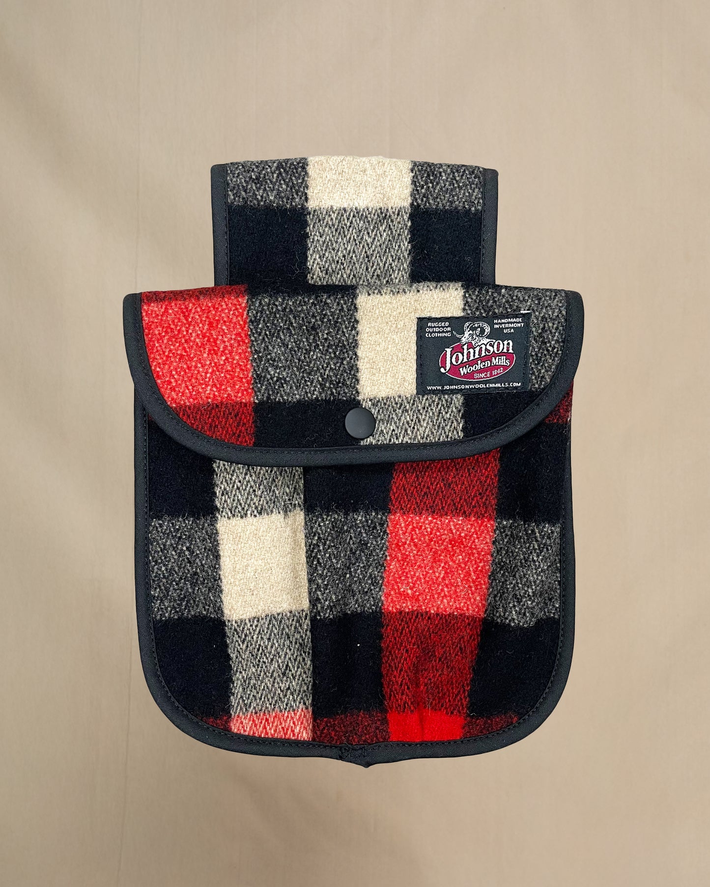 Plaid black powder hunting pouch with Johnson label on a beige background