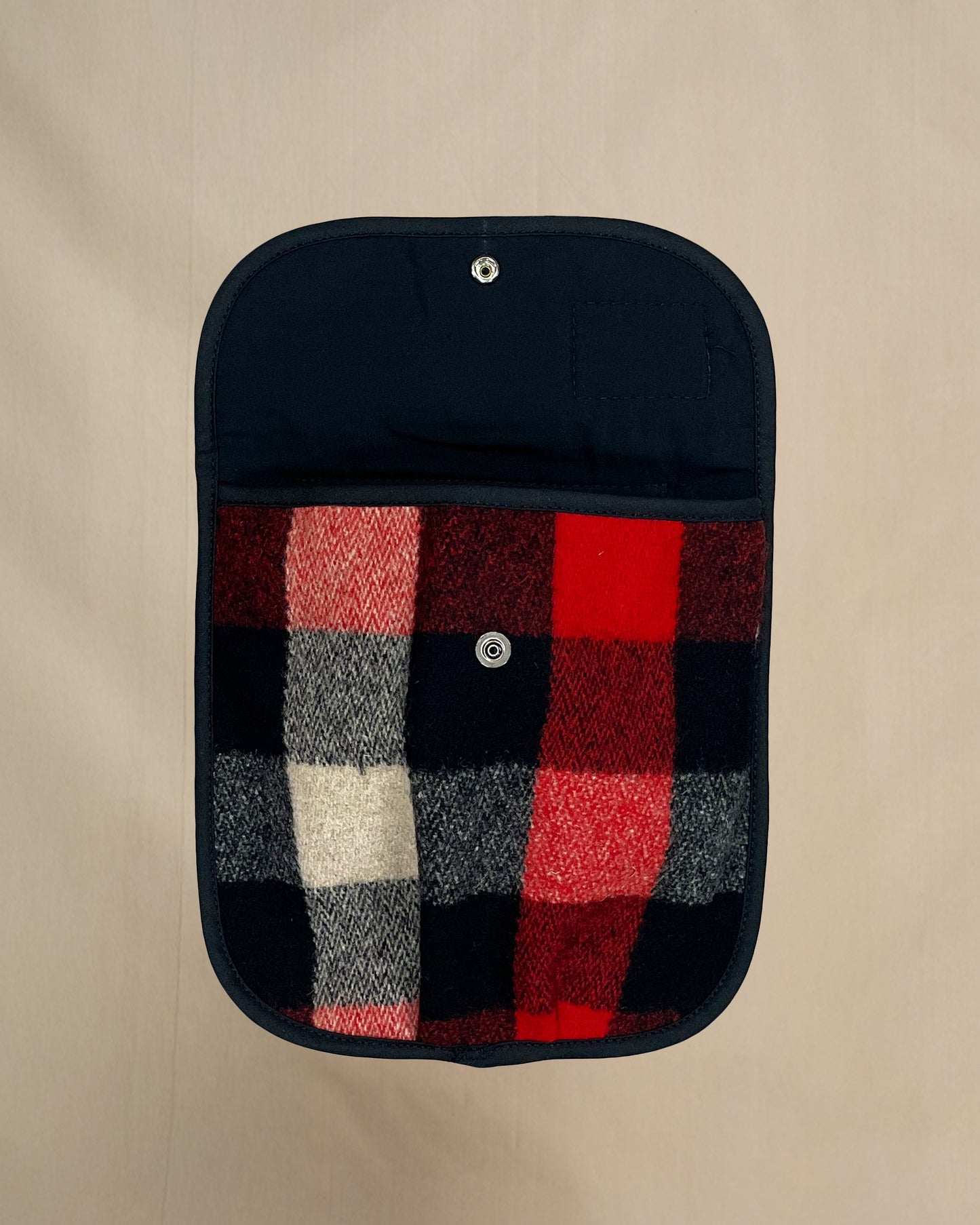 Plaid black powder hunting pouch with Johnson label on a beige background