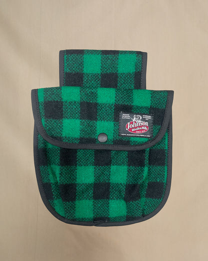 Green and black checkered black powder pouch with a Johnson logo on a beige background