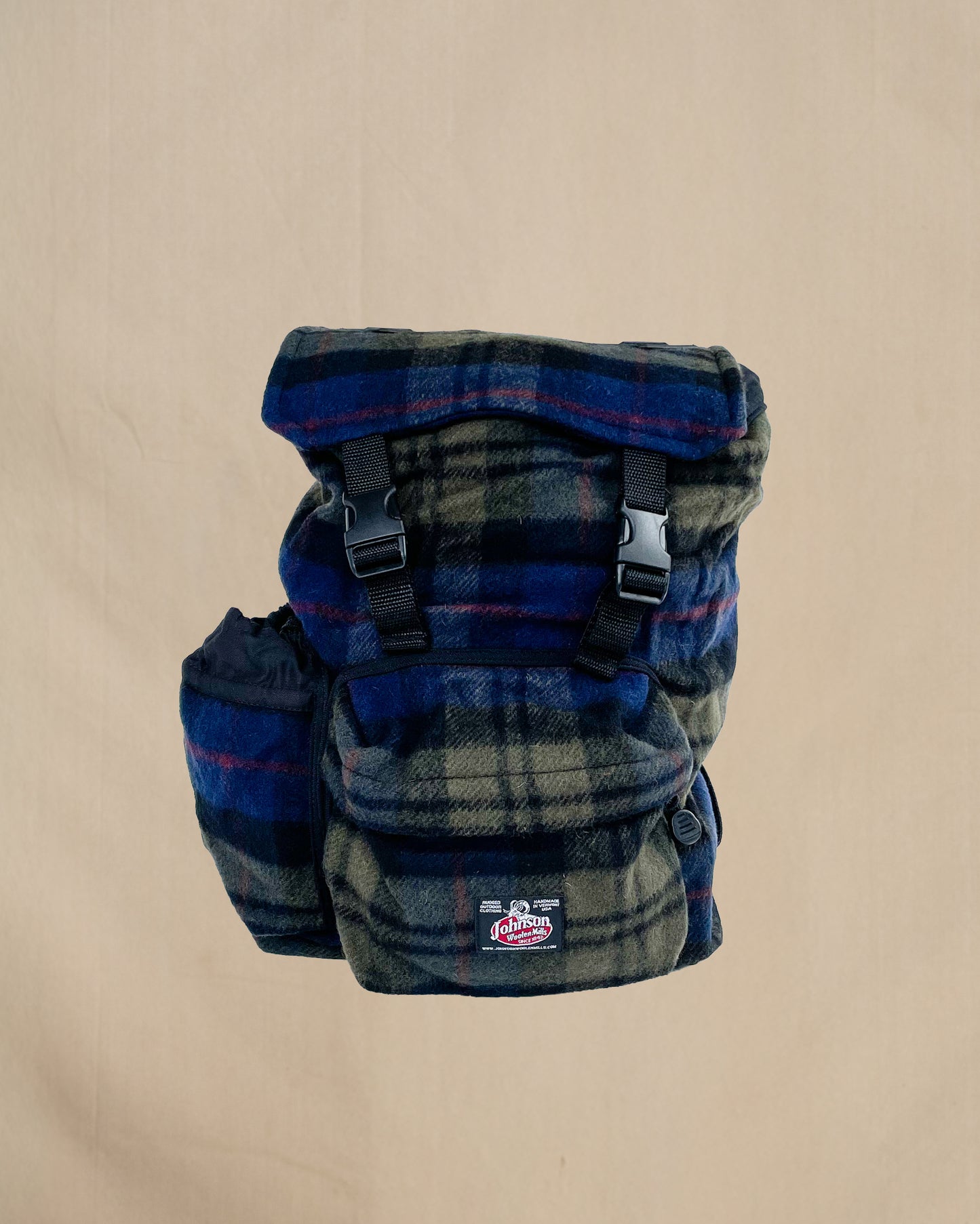 Blue and olive plaid wool backpack with side water bottle pocket, front view 