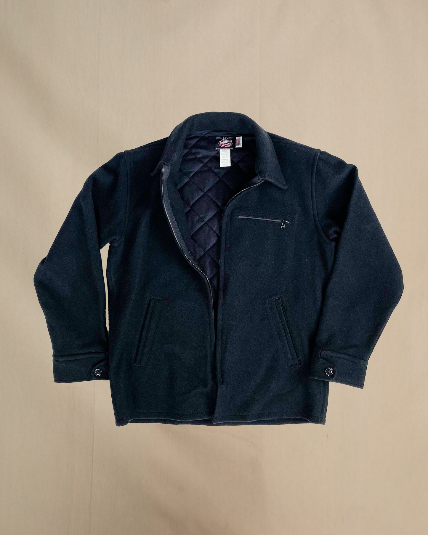 Dark blue jacket with a quilted lining on a beige background