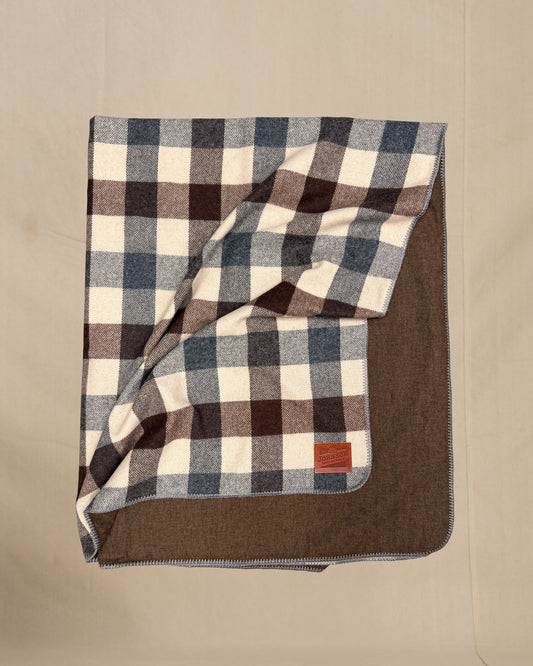 Plaid blanket with brown border on a beige background
