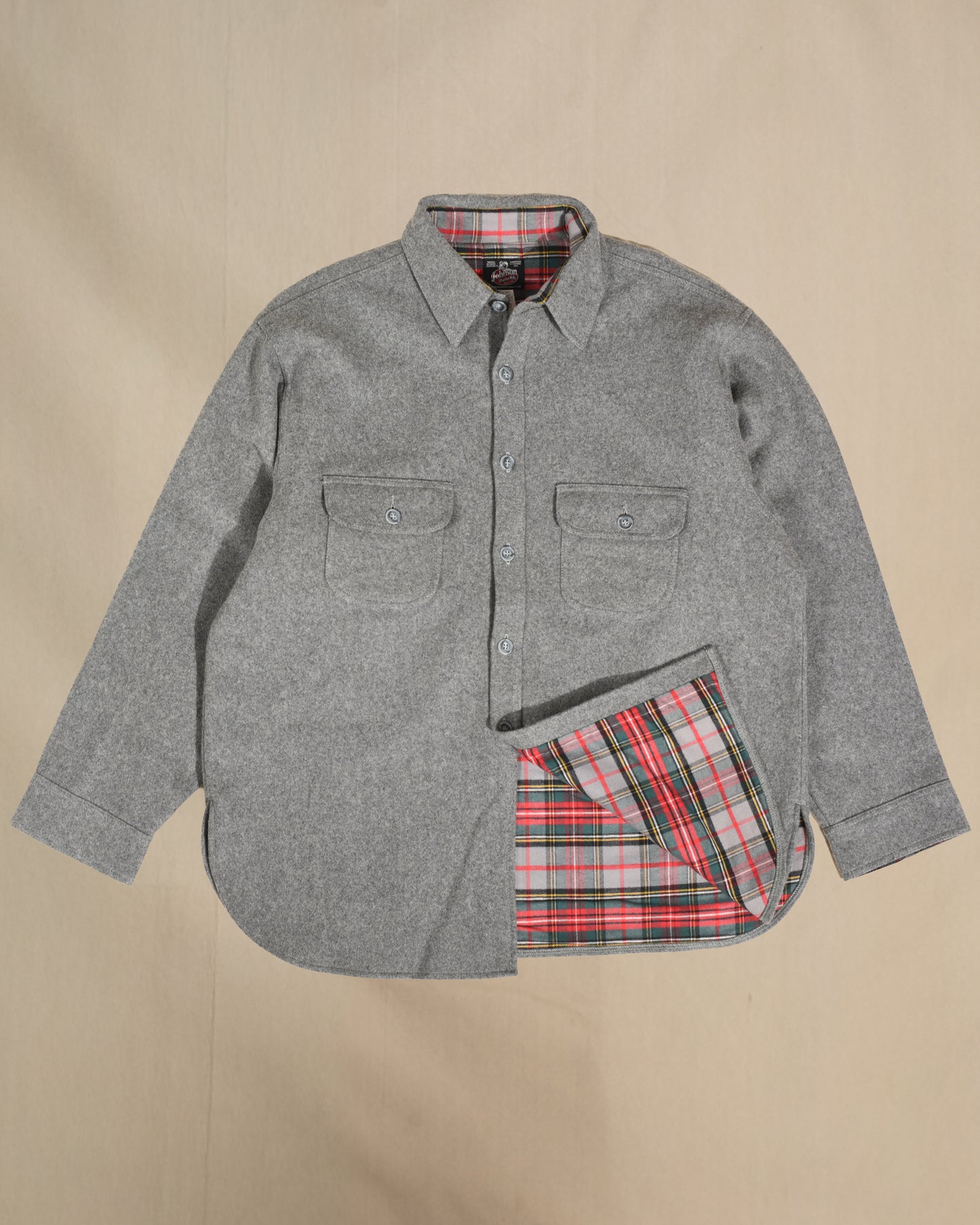 Gray shirt with plaid lining on a beige background