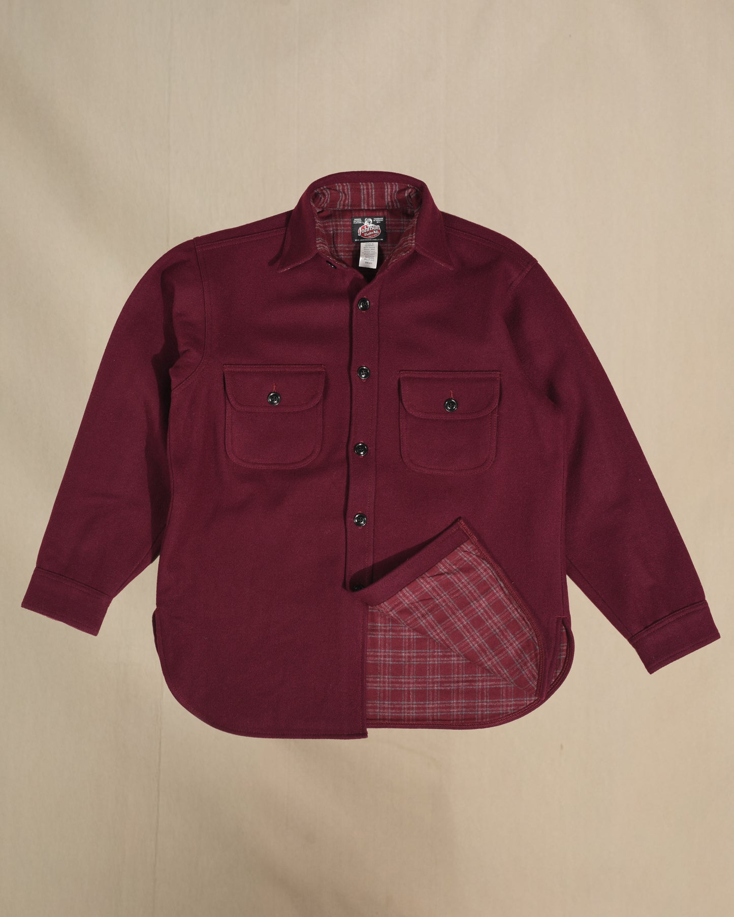 Burgundy shirt with red plaid lining on a beige background