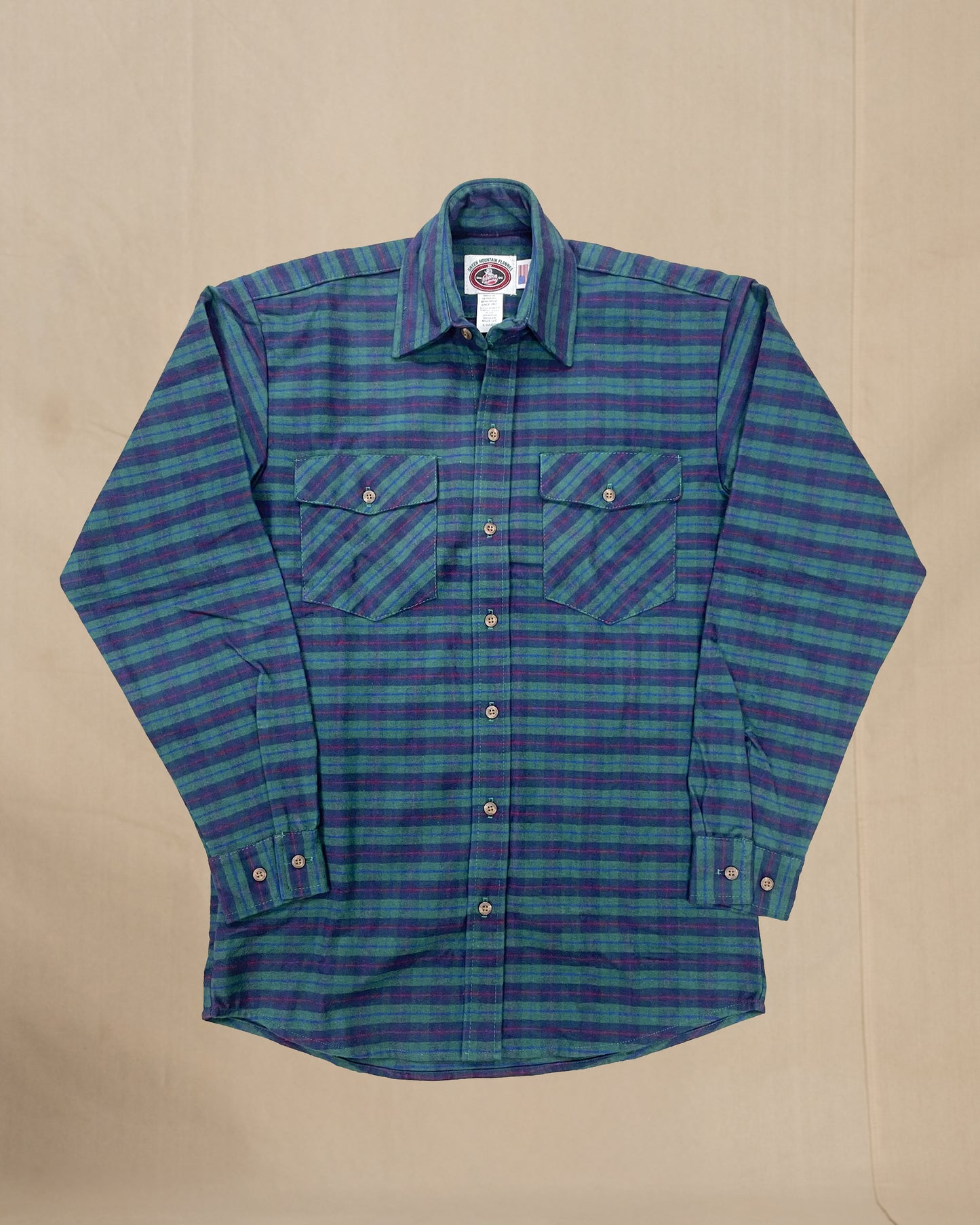 Green and blue plaid shirt on a beige background