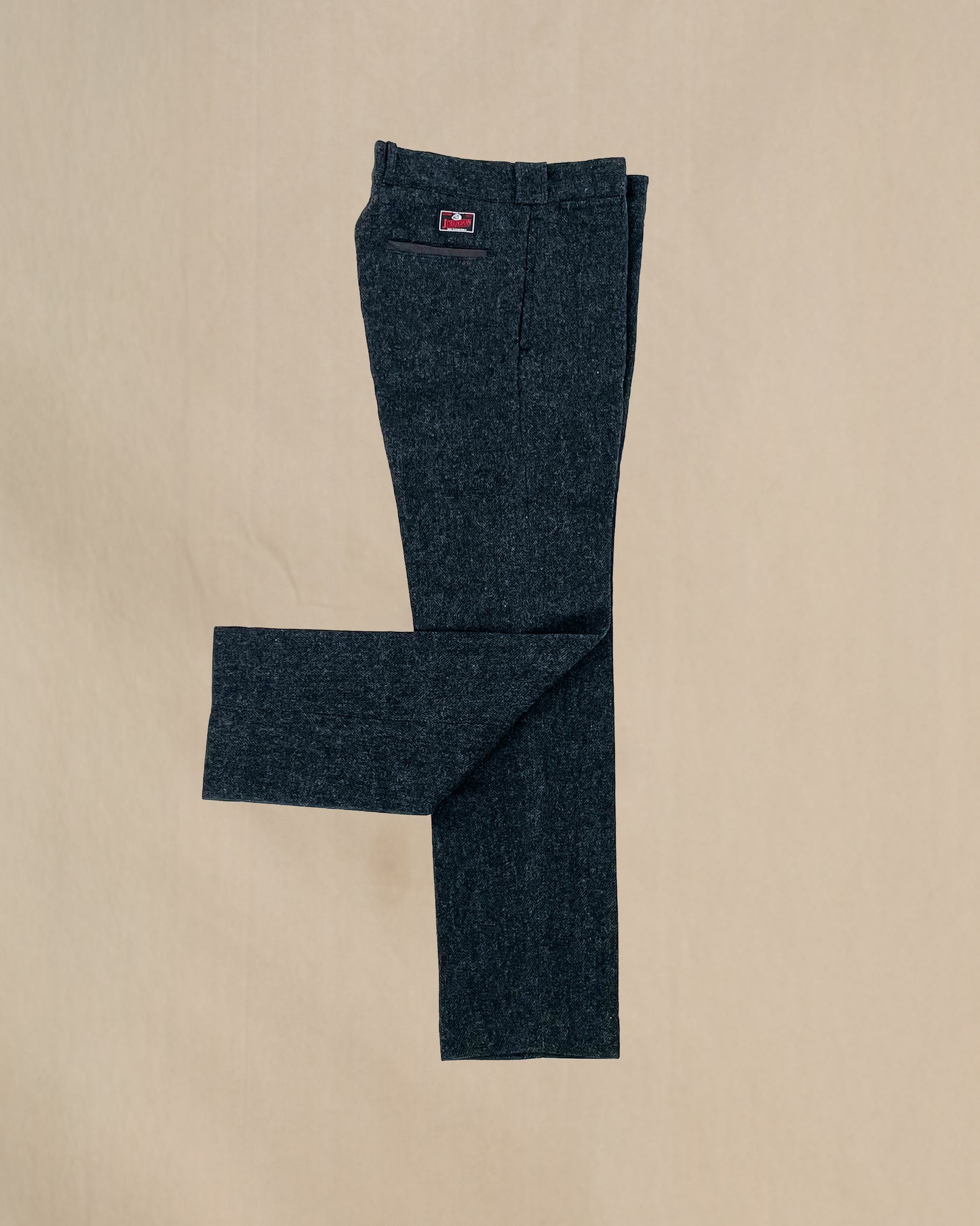 Herringbone gray pants with a johnson logo on a beige background