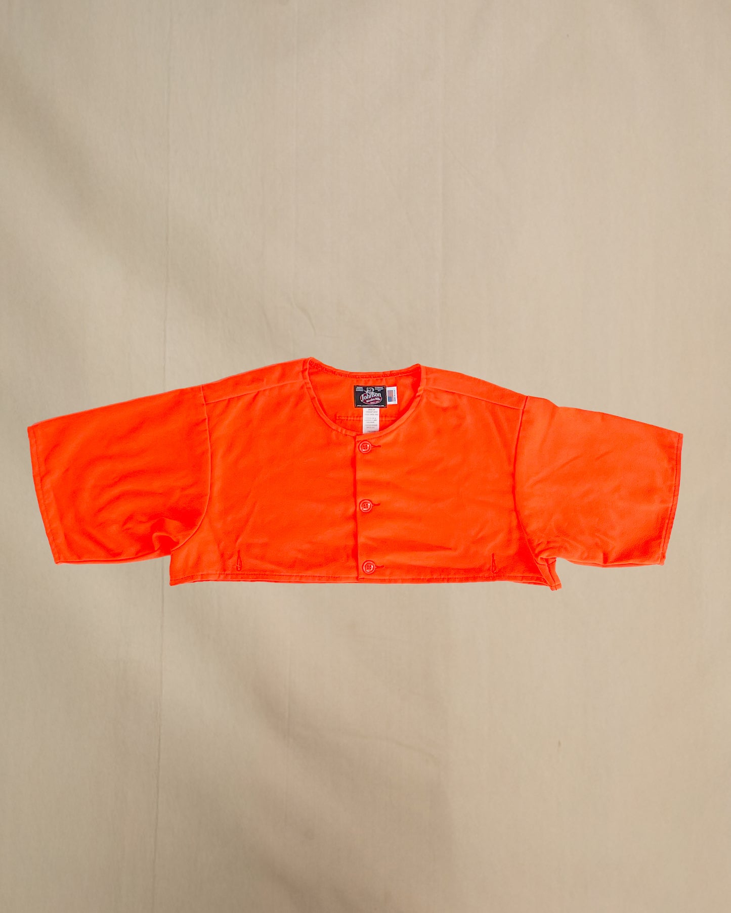 Blaze orange safety cape, designed to work over any Johnson Woolen Mills coat or jacket. Short sleeved, Blaze Orange with three button front & two bottom button holes