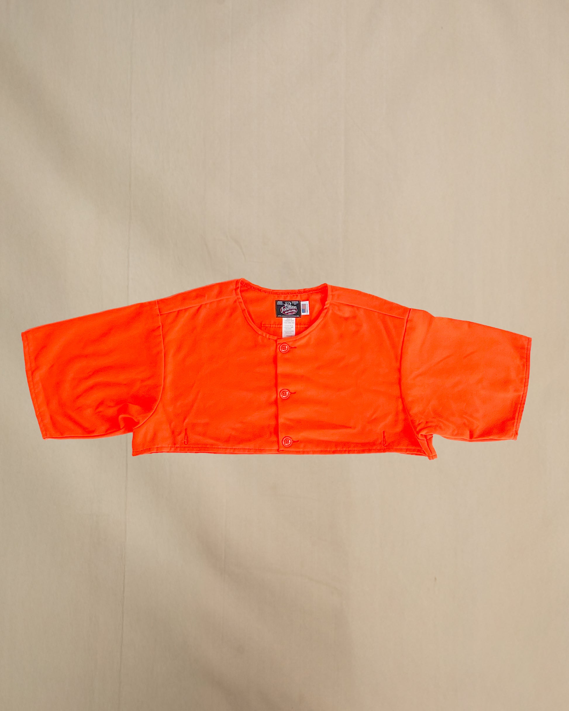 Blaze orange safety cape, designed to work over any Johnson Woolen Mills coat or jacket. Short sleeved, Blaze Orange with three button front & two bottom button holes