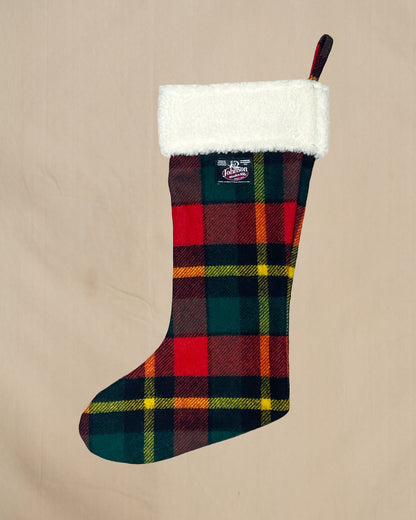 Plaid Christmas stocking with white cuff on a beige background