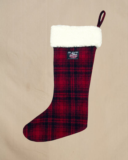 Red plaid Christmas stocking with white cuff on a beige background