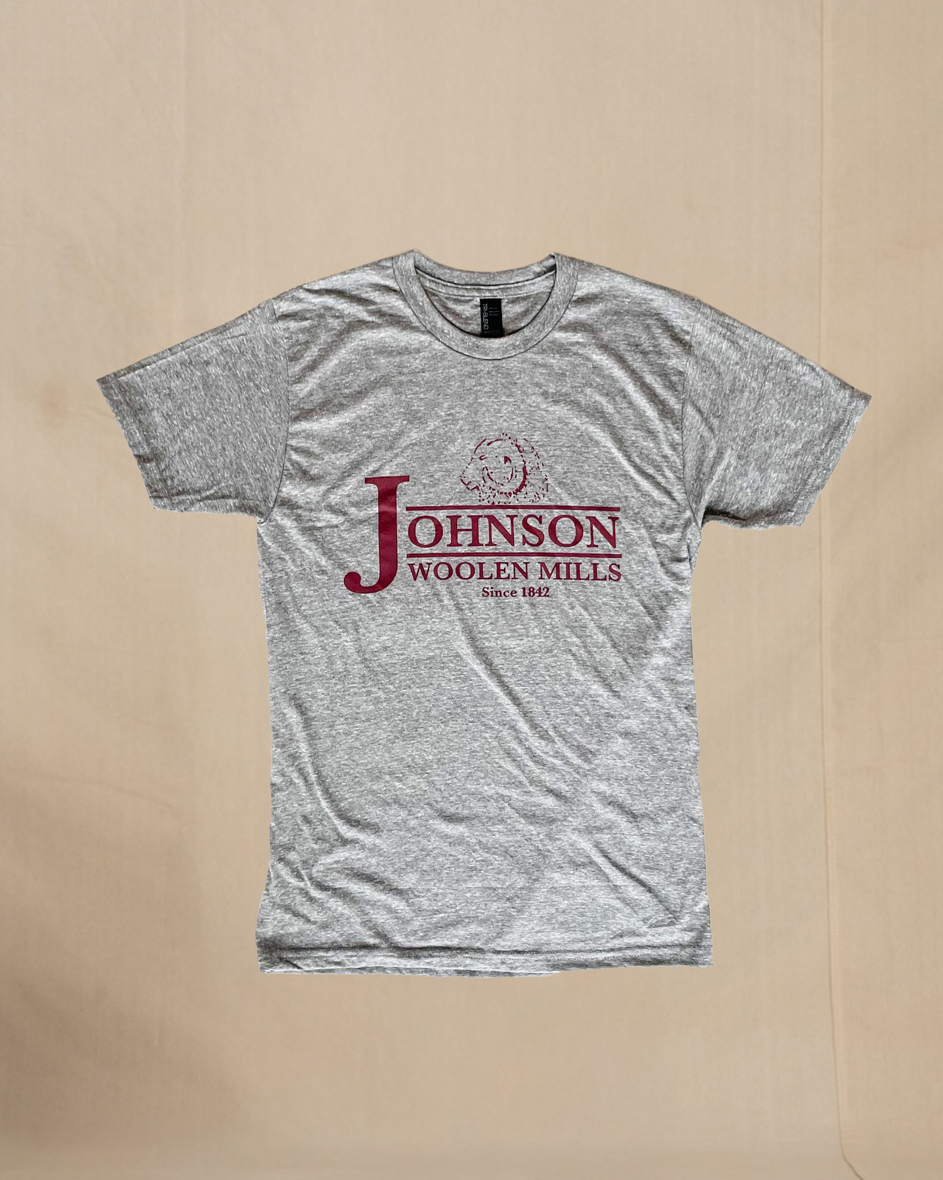 Gray t-shirt with Johnson Woolen Mills logo on a beige background