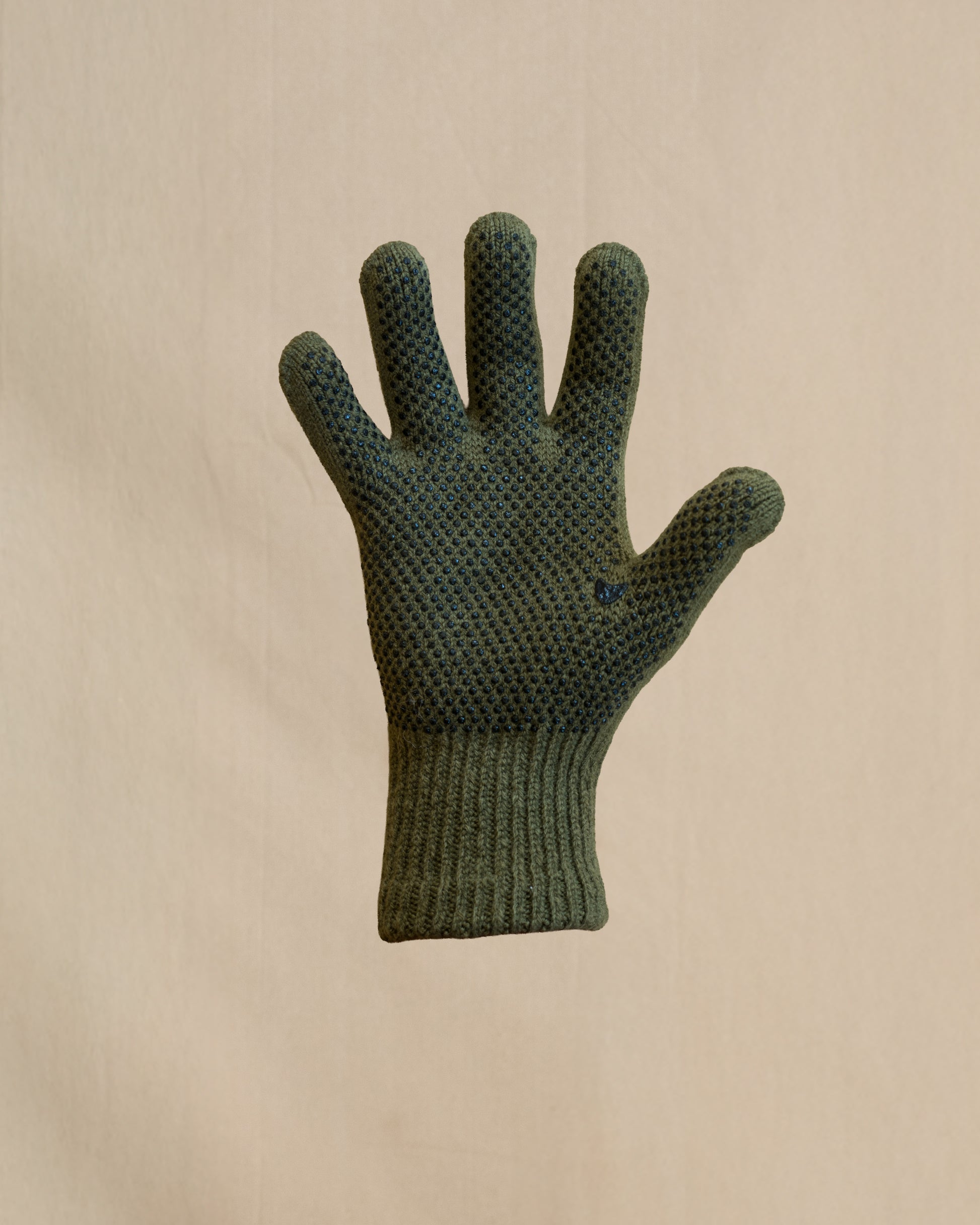 A single knit merino wool glove in olive green. The glove has a small black gripper dots. 