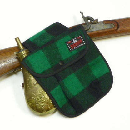 photo of green and black-checked black powder pouch with antique rifle 