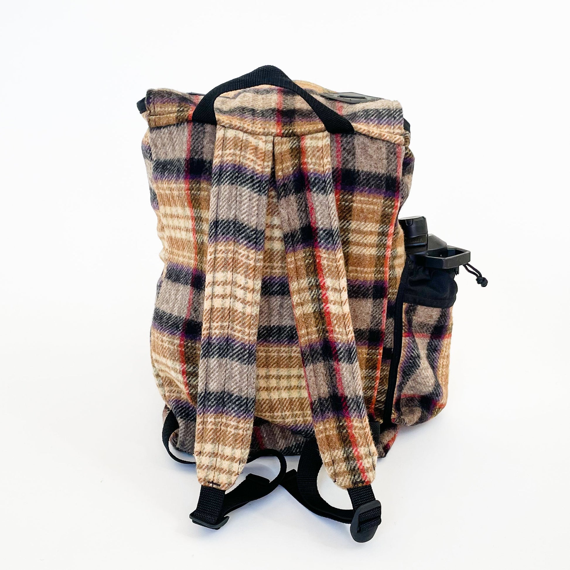 Wool back pack in gold, black and red plaid, shown with water bottle in side pocket - back view