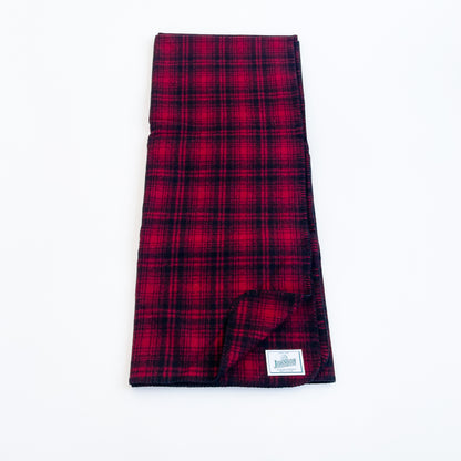 Johnson Woolen Mills Red Black Muted Plaid folded blanket length wise showing logo patch