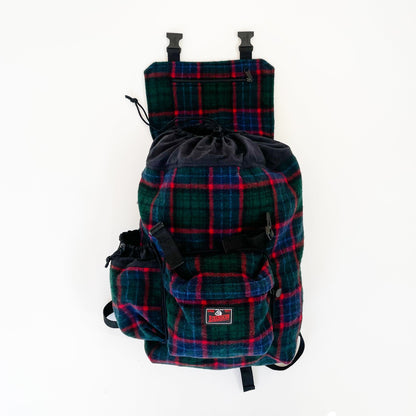 Wool back pack green and blue with red windowpane print, shown with water bottle in side pocket and top flap open