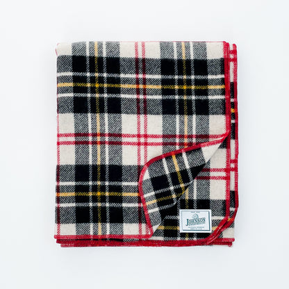 Johnson Woolen Mills throw - black, white yellow plaid with red stitching and logo 